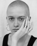 black and white image of woman wearing silver hoops and rings